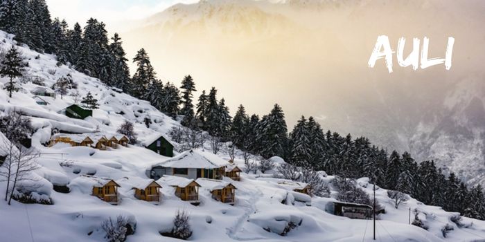 Snow-covered slopes of Auli with snow-clad mountains in the background.