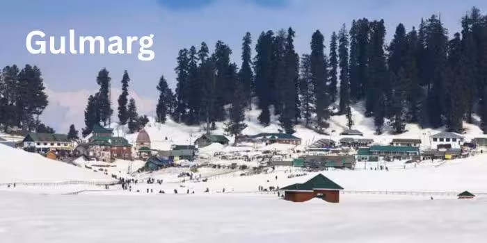 Snow-covered meadows of Gulmarg with misty hills and snow-covered trees.
